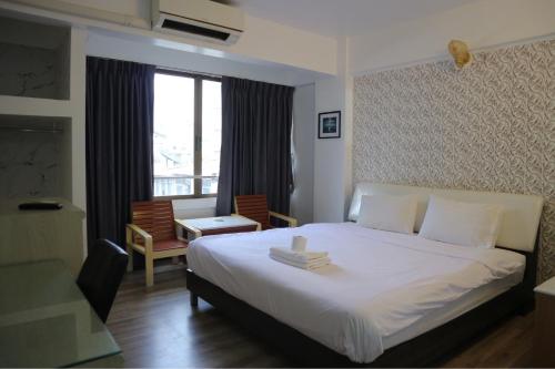 A bed or beds in a room at Crown BTS Nana Hotel