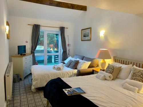 a bedroom with two beds and a living room at Cross Keys Inn in Penrith