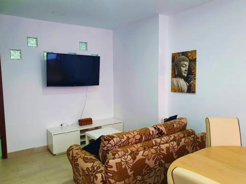 a living room with a couch and a flat screen tv at Stylish one bedroom apartment near the Drago Tree in Icod de los Vinos