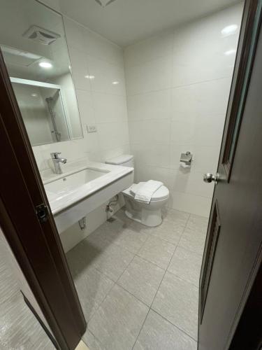 a white bathroom with a toilet and a sink at 苓旅-站前 Lin Inn TMS in Taipei