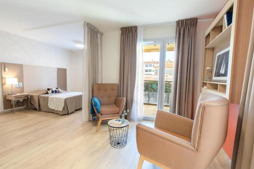 um quarto de hotel com uma cama e uma cadeira em Fréjus Appart'S em Fréjus
