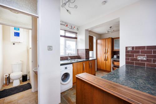 a kitchen with a sink and a washing machine at Head-on-Beds -Dagenham Larger Groups with Free Parking in Dagenham