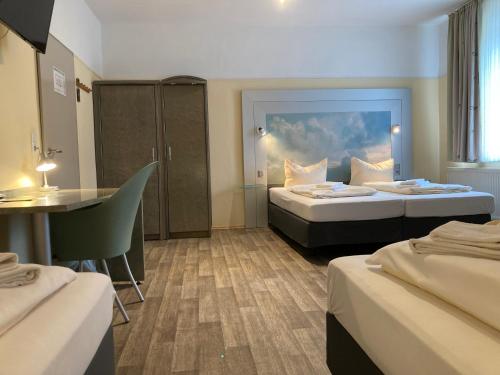 een hotelkamer met 2 bedden en een tafel bij Landhotel Vosse-Schepers in Rhede