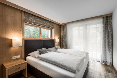 a bedroom with two beds and a window at Chalet Martina Apartments in San Vigilio Di Marebbe