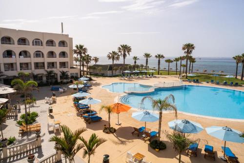 an aerial view of a resort pool with chairs and umbrellas at Khayam Garden Beach Resort & Spa in Nabeul