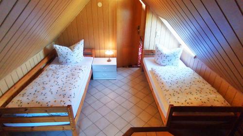 two beds in a small room with a window at Spreewälder Schwalbenhof - Ferienhaus "Schwalbennest" in Golßen