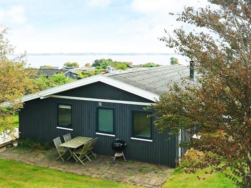 un cobertizo negro con una mesa de picnic y una parrilla en 6 person holiday home in Ebberup en Helnæs By