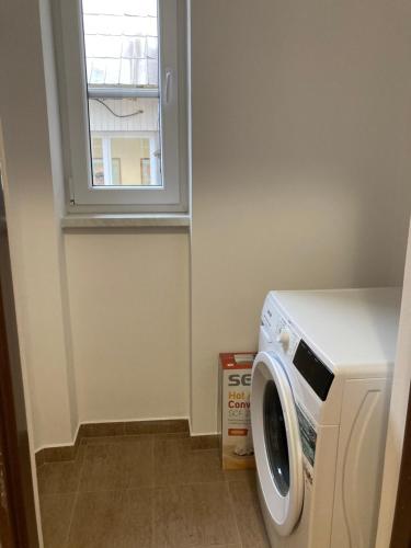 a washing machine in a laundry room with a window at Apartmán Monika in Kraslice