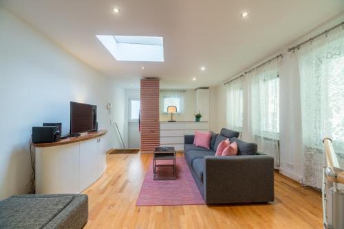 een woonkamer met een bank en een televisie bij Urban Duplex Kreuzberg in Berlijn