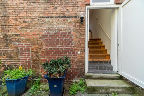 a brick wall with two blue pots in front of a door at Urban Duplex in Berlin