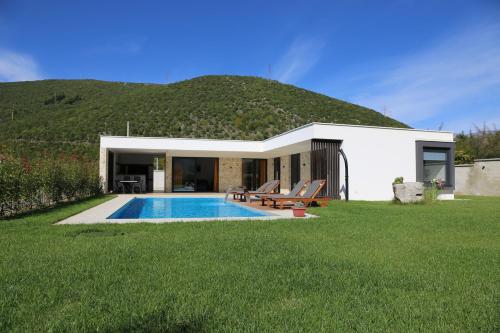 ein Haus mit einem Pool vor einem Hügel in der Unterkunft Villa Nera - Etwa in Mostar