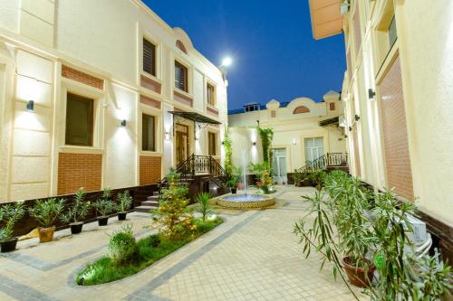 a courtyard of a house with plants and a fountain at Gala Osiyo Samarkand in Samarkand