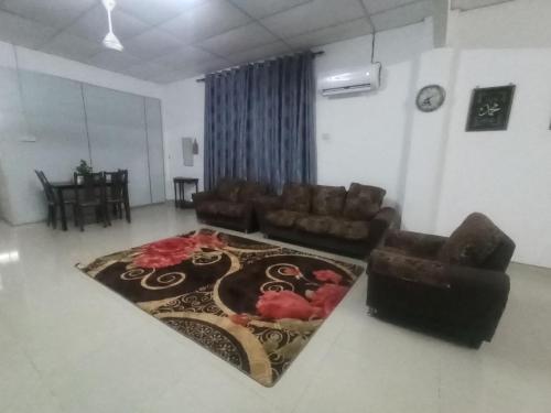 - un salon avec un canapé et un tapis dans l'établissement Rizqy Homestay di Jitra, à Jitra