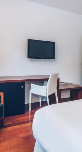 a living room with a tv and a table and chairs at Iberostar Heritage Grand Mencey in Santa Cruz de Tenerife