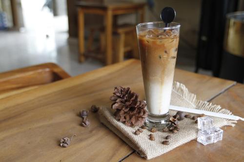 a glass of coffee sitting on a table with a pine cone at Hotel Summerville in Majalengka