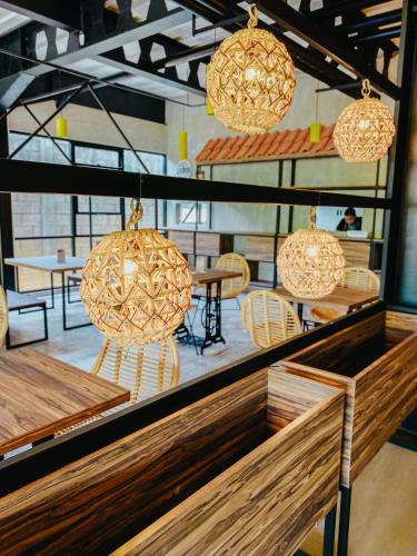 a room with tables and chairs and pendant lights at Hotel Summerville in Majalengka