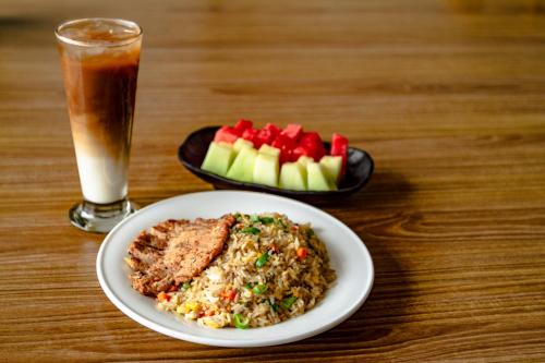 a table with a plate of food and a drink at Hotel Summerville in Majalengka