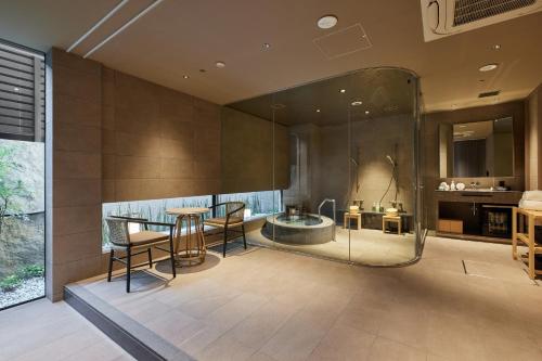 a bathroom with a shower and a table and chairs at THE HOTEL HIGASHIYAMA KYOTO TOKYU, A Pan Pacific Hotel in Kyoto
