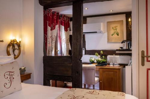 a room with a bed and a kitchen with a table at Hotel Restaurant Le Maréchal - Teritoria in Colmar