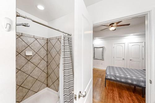 a bathroom with a shower and a bed in a room at College Park Cottage in Atlanta