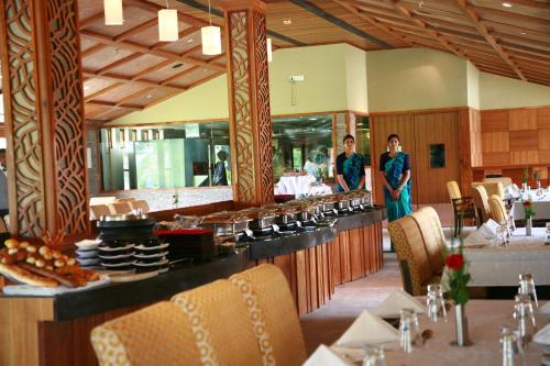 a restaurant with two people standing at a buffet at Madhubhan Resort & Spa in Anand
