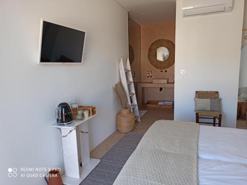 a bedroom with a bed and a tv on a wall at Casa Rural Pucariças - Country & Nature in Proença-a-Nova
