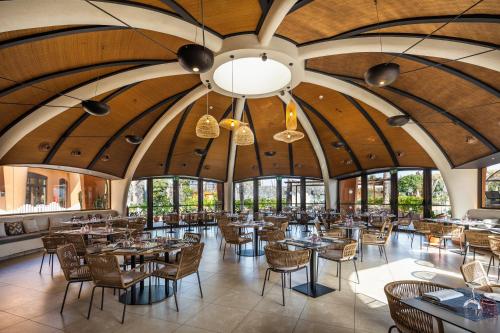 a dining room with tables and chairs and large windows at Barceló Tenerife in San Miguel de Abona