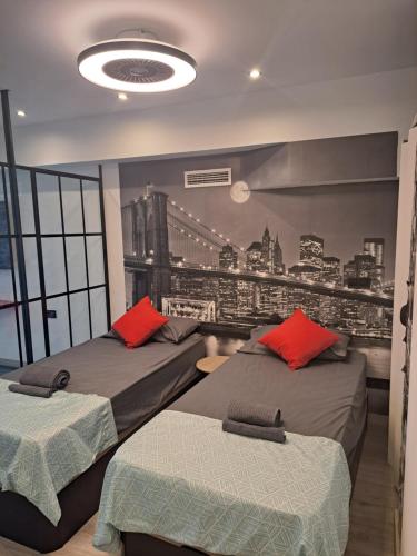 two beds in a room with a city mural on the wall at Moraleja Suite I in Alcobendas