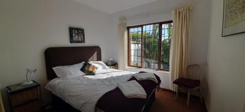 a bedroom with a bed and a window at The Spotted Owl in Cape Town