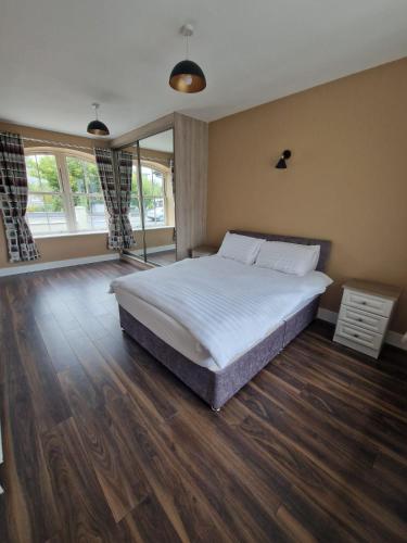 a bedroom with a large bed and wooden floors at Mountmahon House in Abbeyfeale
