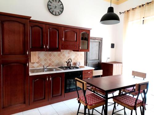 a kitchen with a table and a clock on the wall at Appartamento Porto Marina VA1 in Licata