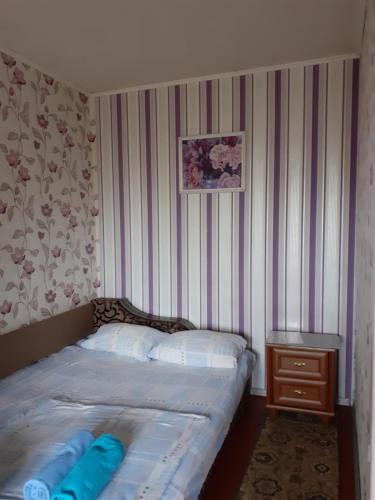 a small bedroom with a bed with blue pillows at Чорних Запорожців 17, інститут серця in Kyiv