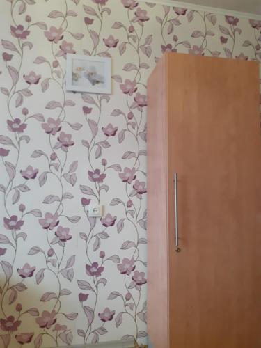 uma parede com um papel de parede florido e um armário de madeira em Чорних Запорожців 17, інститут серця em Kiev
