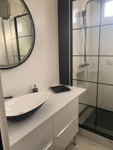 Baño blanco con lavabo y espejo en Neuilly-Sur-Seine : 2 pièces 40 m2- central en Neuilly-sur-Seine