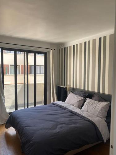 1 dormitorio con cama y ventana grande en Neuilly-Sur-Seine : 2 pièces 40 m2- central en Neuilly-sur-Seine