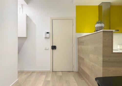 kuchnia z białymi drzwiami i żółtymi ścianami w obiekcie Stay U-nique Apartments Sants w Barcelonie