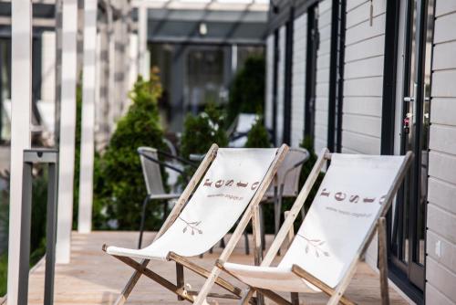 two folding chairs sitting on a porch at Resto domki letniskowe in Sarbinowo