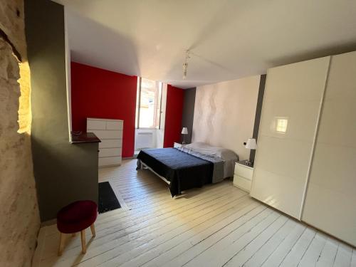 1 dormitorio con cama y pared roja en Wine house en Chablis