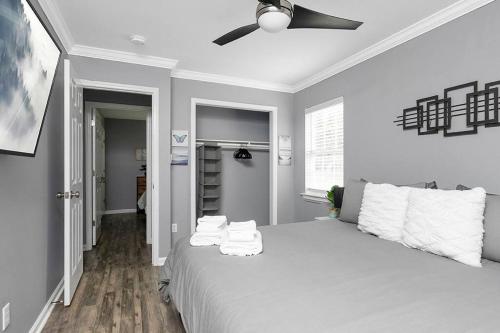 a bedroom with a large bed with a ceiling fan at Unique Cozy Home 6 Min 2 Uptown Fire Pit & Yard in Charlotte