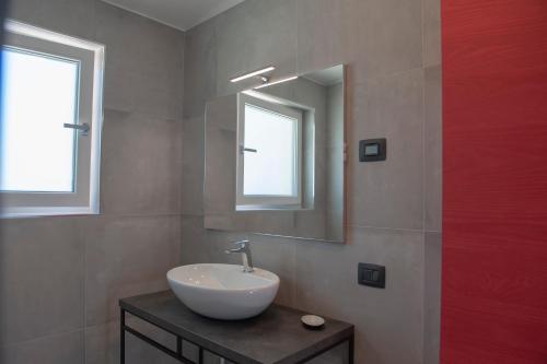 a bathroom with a sink and a mirror at Lough appartamento in Colà di Lazise