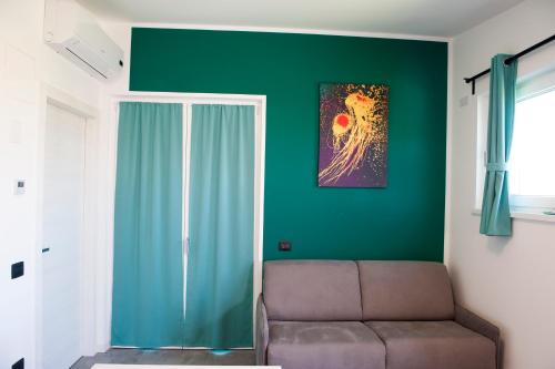 a living room with a couch and a green wall at Lough appartamento in Colà di Lazise