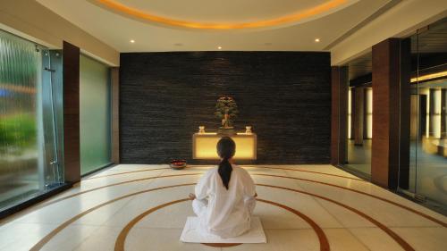 a woman in a white robe sitting in a room at Madhubhan Resort & Spa in Anand