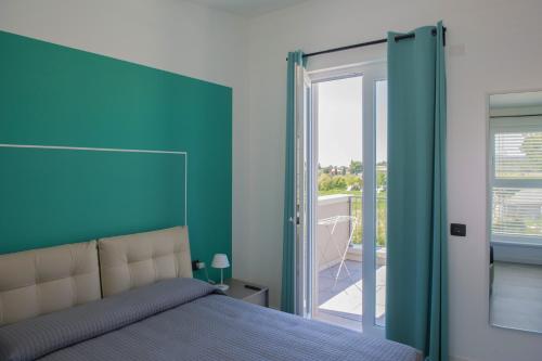 1 dormitorio con 1 cama con pared azul en Lough appartamento, en Colà di Lazise