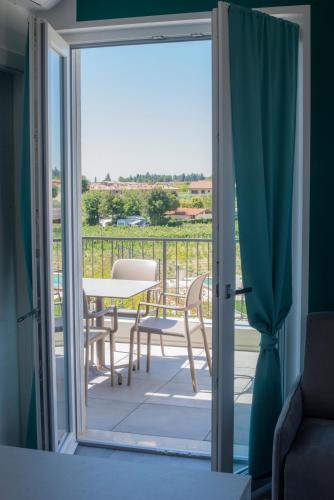 a sliding glass door leading to a balcony with a table and chairs at Lough appartamento in Colà di Lazise