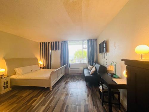 a bedroom with a bed and a couch and a window at TAMPA BAY, BEACH step away, WIFI, FREE PARKING,POOLS, JACUZZI in Ruskin