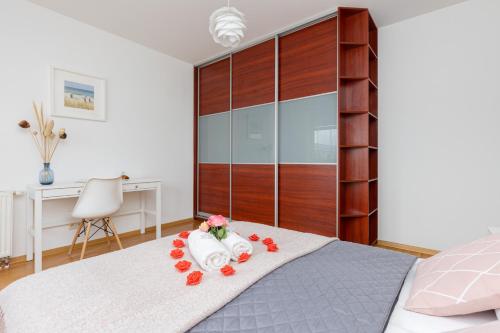 a bedroom with a large bed with a desk and a chair at Spacious Apartment Pałac Jana III Wilanów by Renters in Warsaw