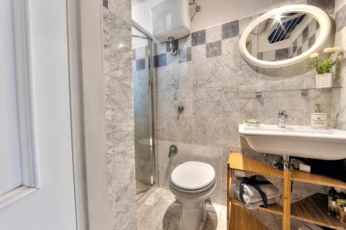 a bathroom with a toilet and a sink and a shower at Santo Spirito Romantic by Mmega in Florence