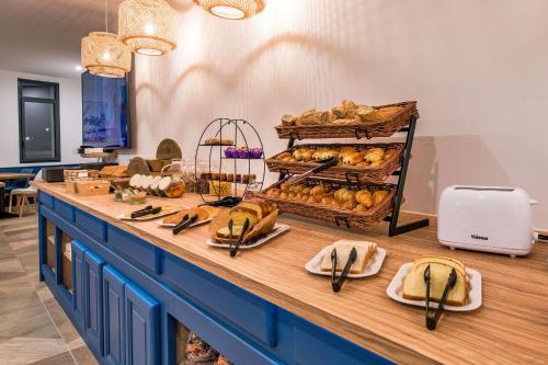 een buffet met brood en zoete deegwaren op een tafel bij Hôtel Le Cyrano Bergerac in Bergerac