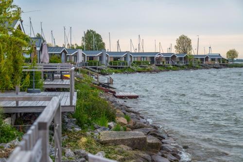 a row of houses next to a river at EuroParcs Markermeer in Bovenkarspel