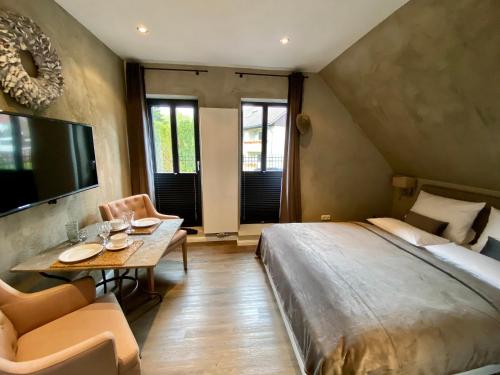 1 dormitorio con 1 cama grande, mesa y sillas en country-suites by verdino LIVING - Apartments & Privatzimmer, en Braunlage